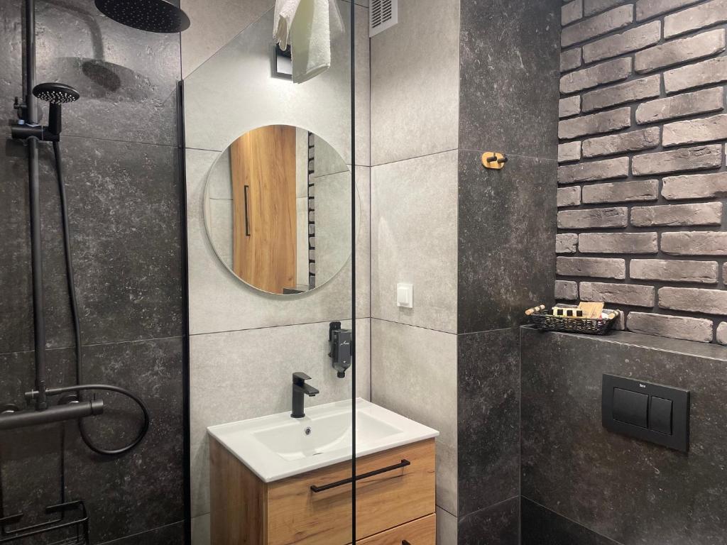 een badkamer met een wastafel en een spiegel bij Apartament Poezji A39 Grey in Gliwice