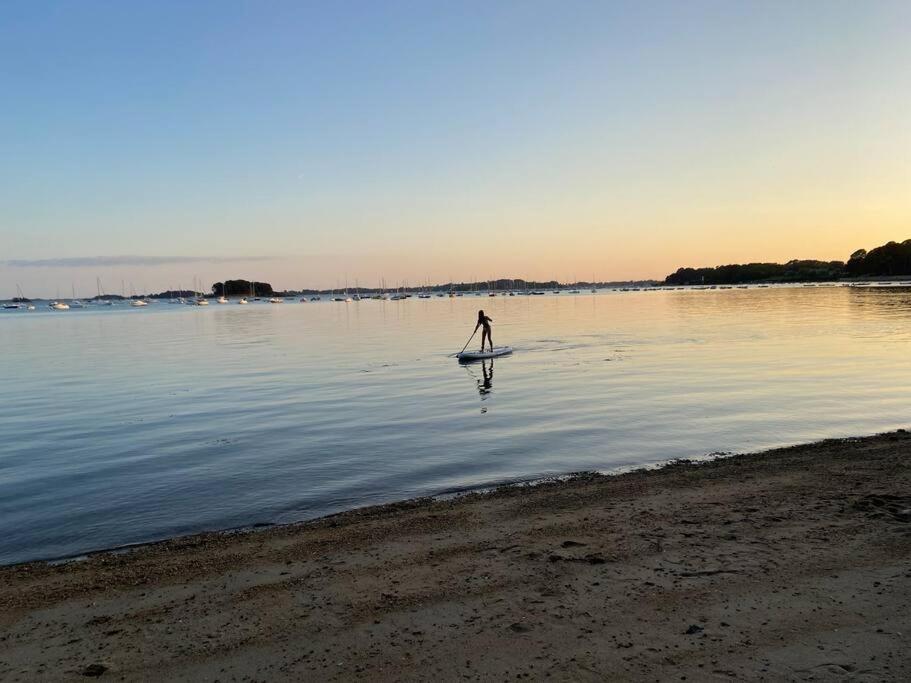 a person is standing on a paddle board in the water at L’Arabesque, villa de charme avec piscine in Arradon