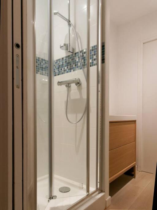 a shower with a glass door in a bathroom at L’Arabesque, villa de charme avec piscine in Arradon