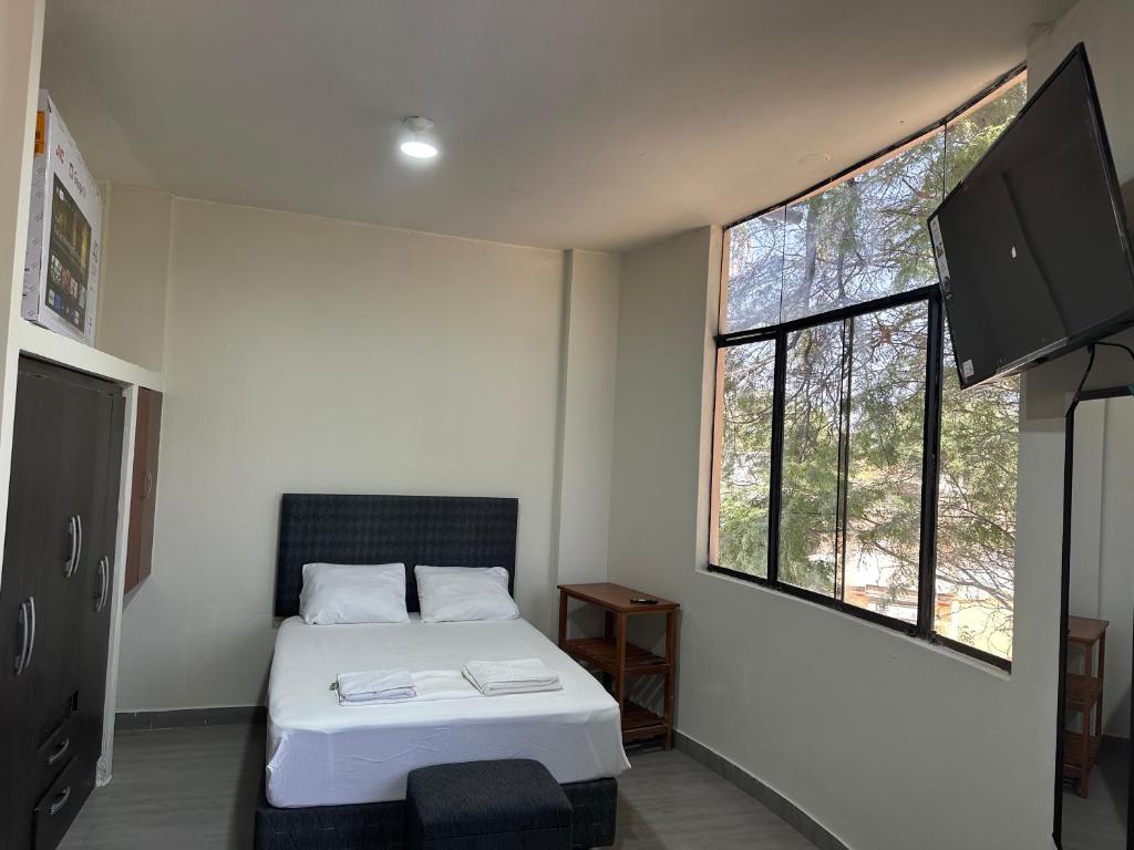 a bedroom with a bed and a large window at Casa Mimaya dpto301 in Piura