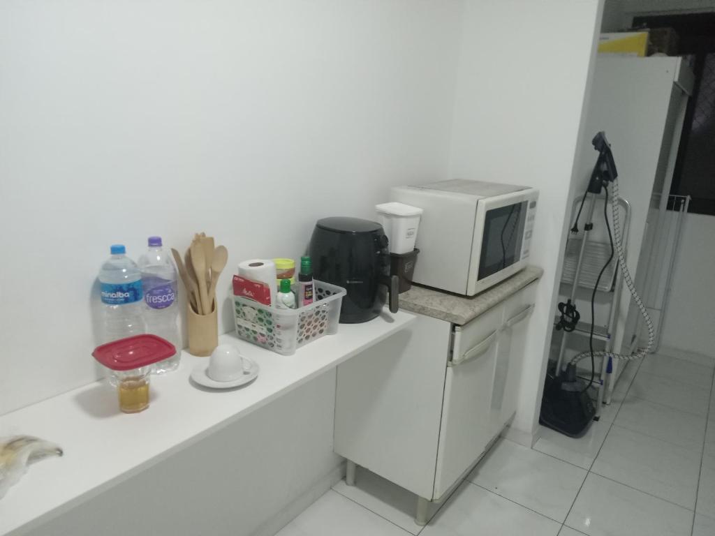 eine Mikrowelle auf einer Theke neben einer Küche in der Unterkunft Apartamento condomínio Taboão da Serra/ familysnow in Taboão da Serra