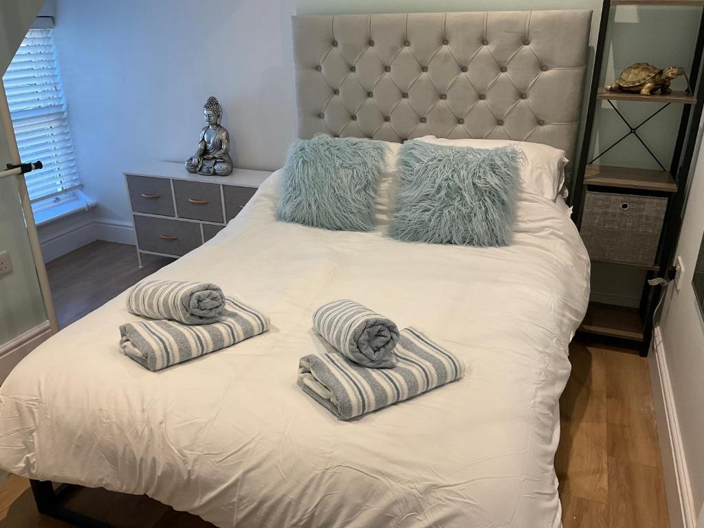 ein Bett mit zwei Handtüchern und Kissen darauf in der Unterkunft 2 bed Home from Home Apartment 41 in London