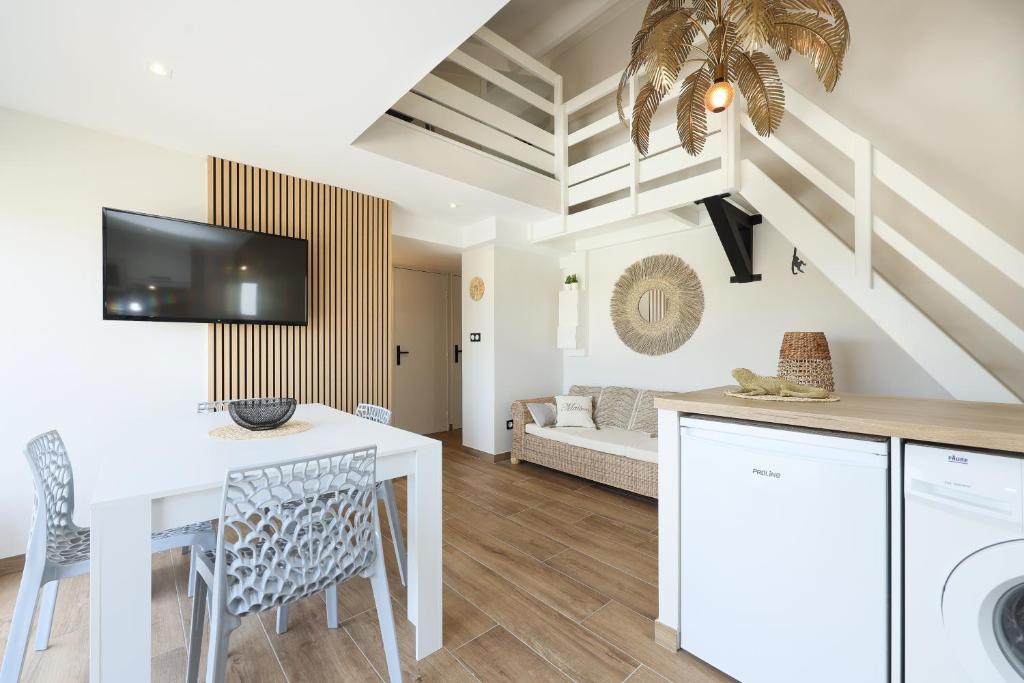 聖西普里安的住宿－Fare Laurent，厨房以及带白色桌椅的起居室。