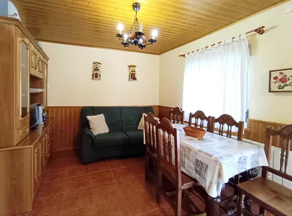 a dining room with a table and a couch at CASA RASPA, BATERNA (ÁVILA) in Baterna