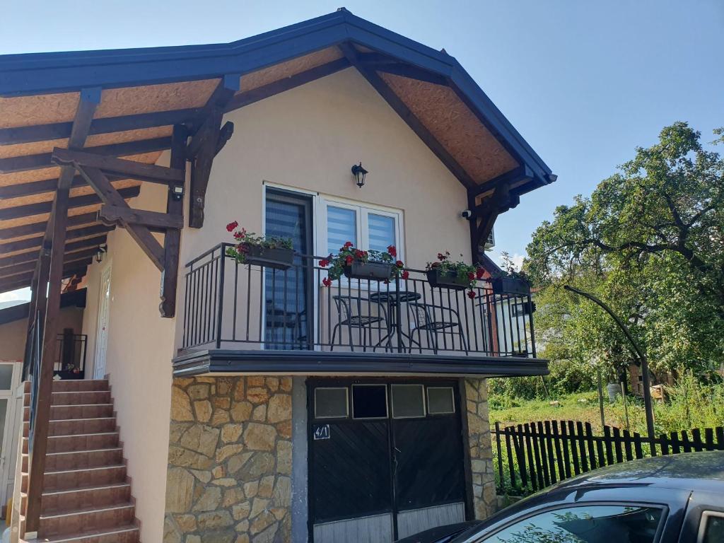 a house with a balcony with a table and chairs at Apartman Nikolina in Bajina Bašta