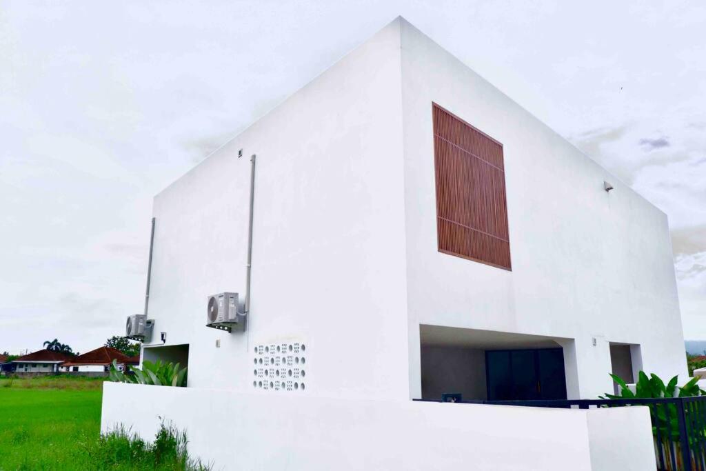 um edifício branco com uma grande janela em The Rice Villas วิวทุ่งนาภูเขา 2King beds& hot Bathtub em San Sai