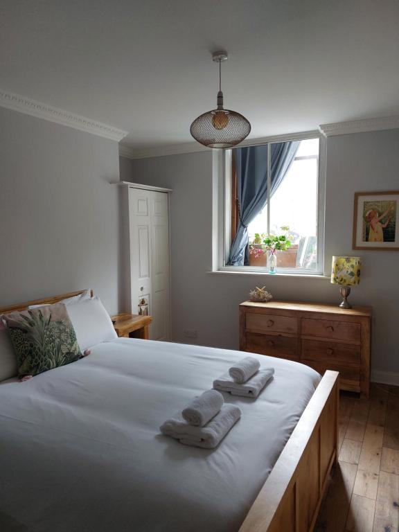 a bedroom with a bed with two towels on it at Portobello Charming Seaside 3-BR Holiday Apartment in Edinburgh