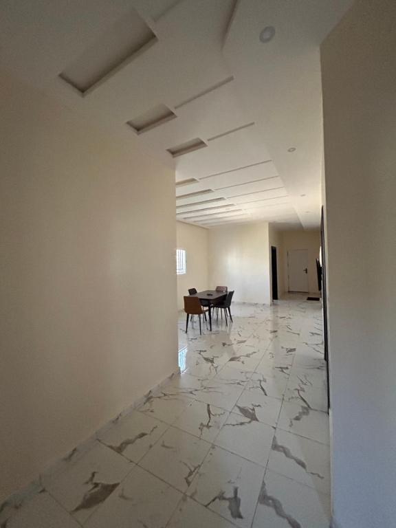 an empty room with a table in the distance at Maison Blanche in Nouakchott