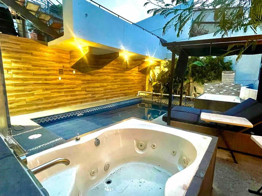a bath tub in a room with a pool at LOFT Estilo & Diseño ALBERCA, 2 JACUZZIS PRIVADOS CLIMATIZADOS con HIDROMASAJE PROFESIONAL TIPO SPA, Terraza y Asador de Carbon in Cuernavaca