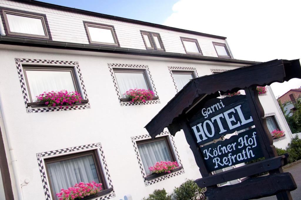 a white hotel with a sign in front of it at Hotel Kölner Hof Refrath in Bergisch Gladbach