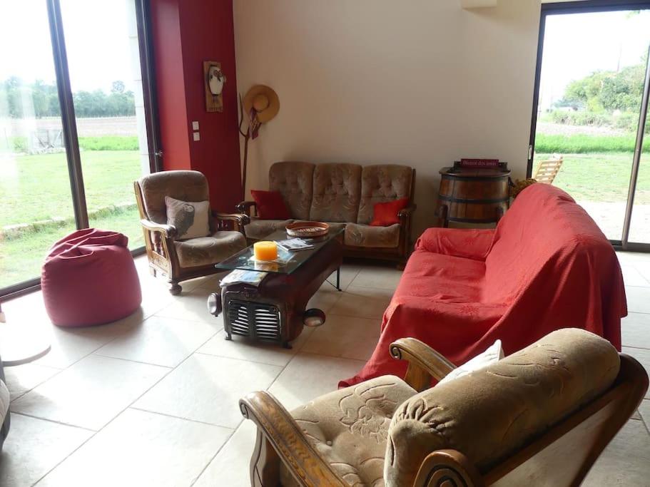 sala de estar con sofá, sillas y mesa en Les Chouettes Blanches, en Benet