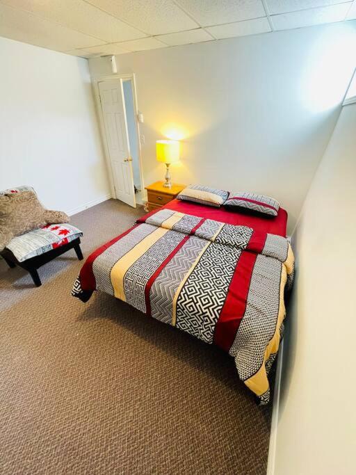 um quarto com uma cama e uma cadeira num quarto em Appartment in Iroquois falls em Iroquois Falls