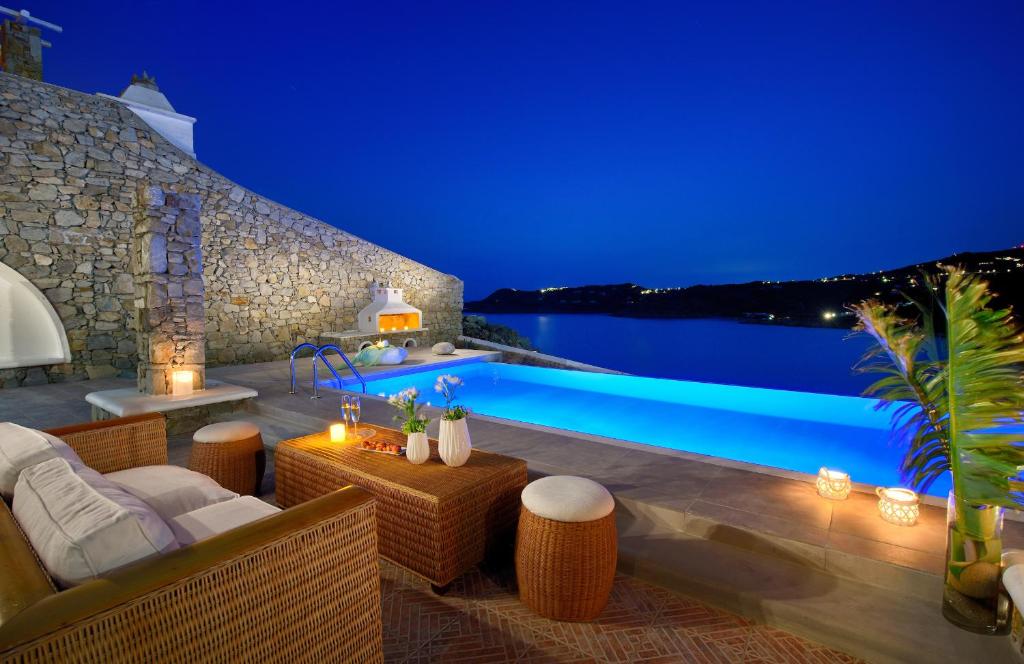a villa with a swimming pool at night at Luxurious Villa Ostria in Elia Beach
