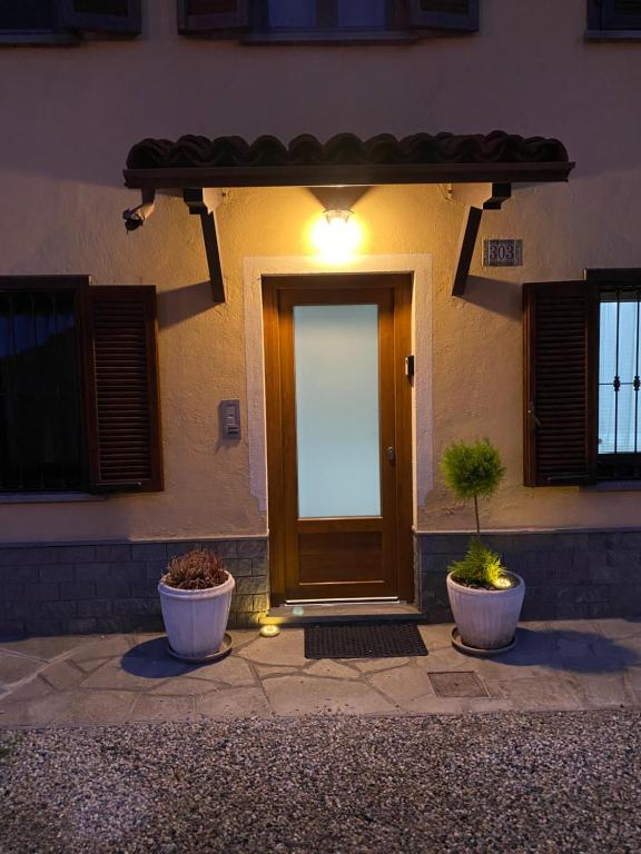 una porta d'ingresso di una casa con due piante in vaso di Semplicità ,Relax a Pinerolo