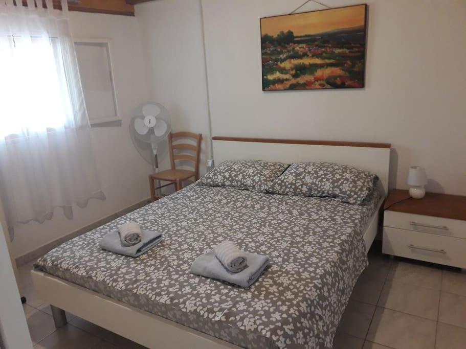 a bedroom with a bed with two towels on it at Robinson house Sea & olives in Tisno
