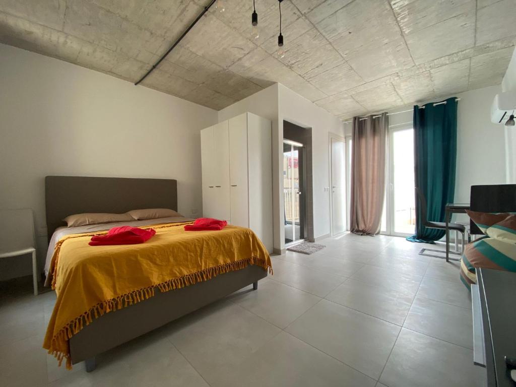 a bedroom with a bed with red pillows on it at Minimal & Arty Townhouse in Hamrun