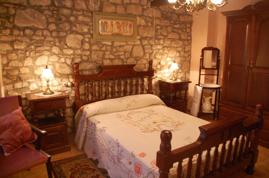 um quarto com uma cama e uma parede de pedra em Cal Balico Fatarella em Fatarella