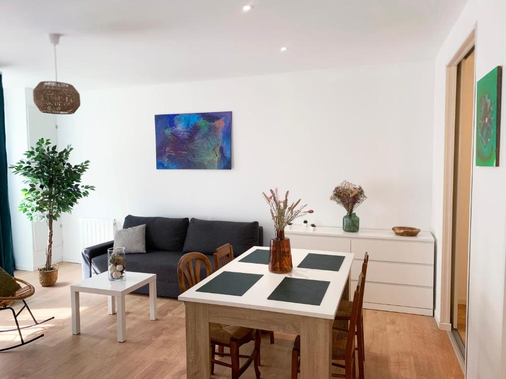 un salon avec une table et un canapé dans l'établissement Appartement centre-ville cosy WIFI et Netflix, à Fontenay-le-Comte