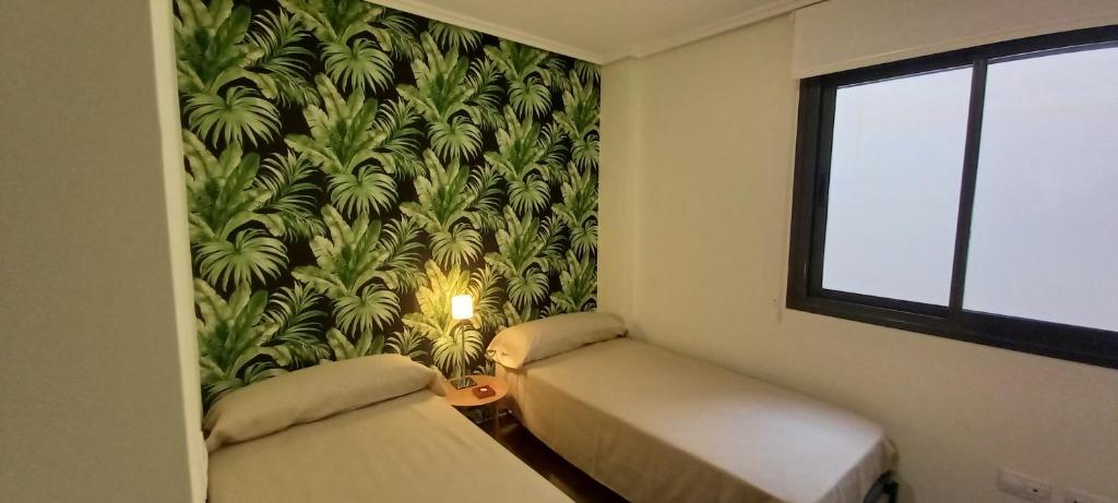 um quarto com 2 camas e uma parede com um mural em Apartamento en el Zapillo, Las Conchas II em Almeria