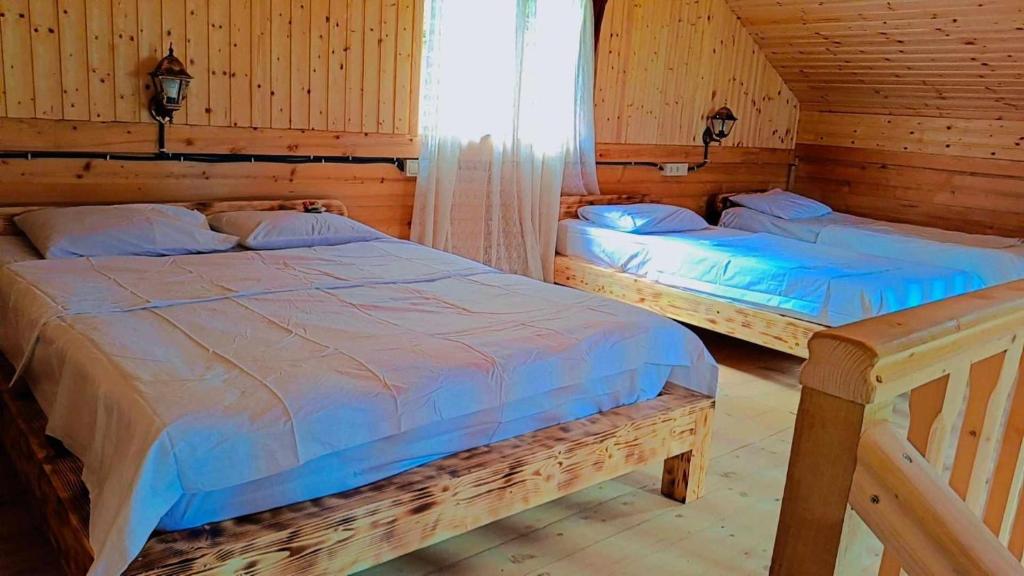 Duas camas num quarto com paredes de madeira em My house em Batumi