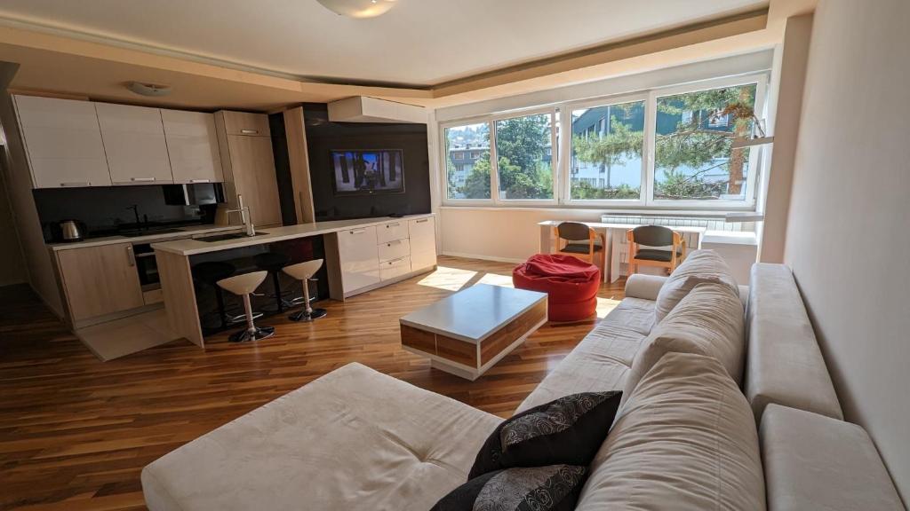 un soggiorno con divano e una cucina di Modern and cozy apartment, excellent location, near Sarajevo City Center, 60m2 a Sarajevo
