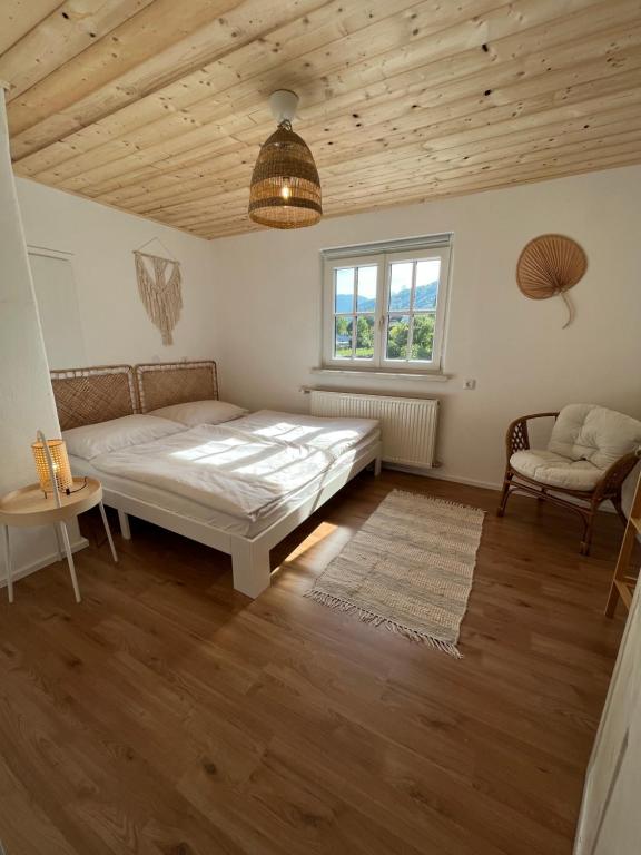 een slaapkamer met een bed, een bank en een raam bij Boho Home am Bach in Altmünster