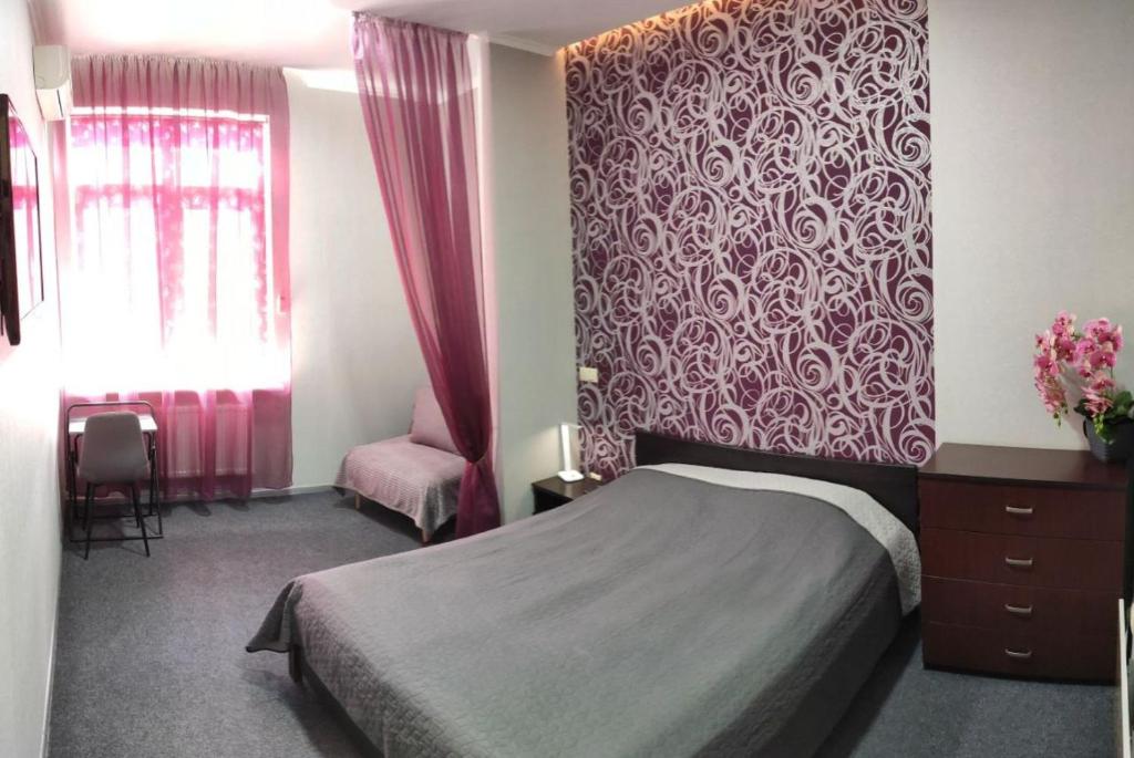 ein Schlafzimmer mit einem Bett und einer roten Wand in der Unterkunft Lux Apart Lviv apartments in Lwiw