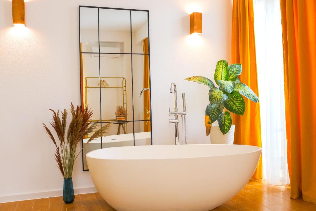 a bathroom with a large white tub and a shower at Mohika Aparthotel in Tbilisi City