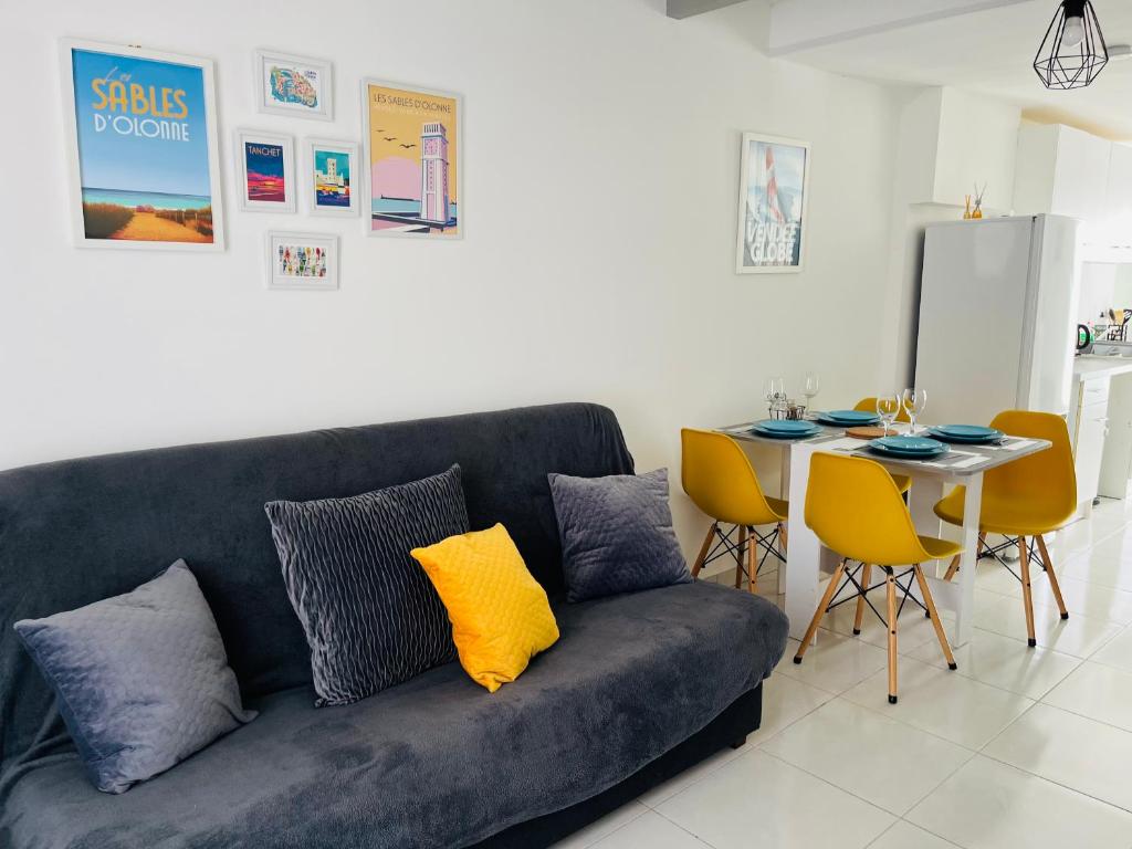 uma sala de estar com um sofá e uma mesa em Le 18B em La Pironnière
