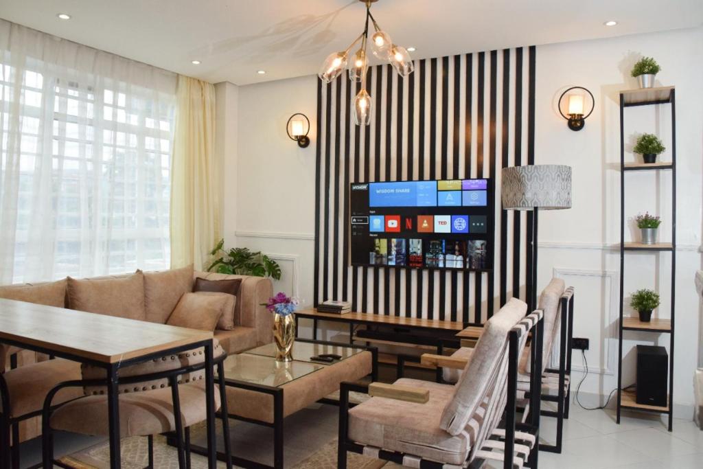 Executive Two & Three Bedroom Suites في ناكورو: غرفة معيشة مع أريكة وطاولة