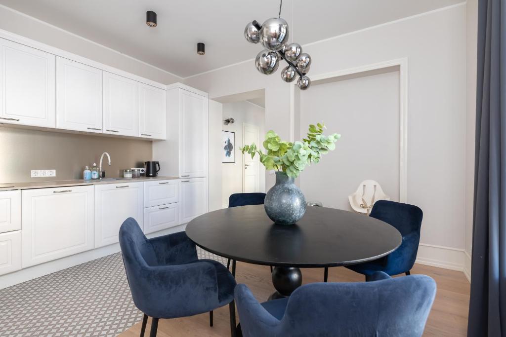 a kitchen and dining room with a table and blue chairs at Hilltop Apartments - City Centre in Tallinn