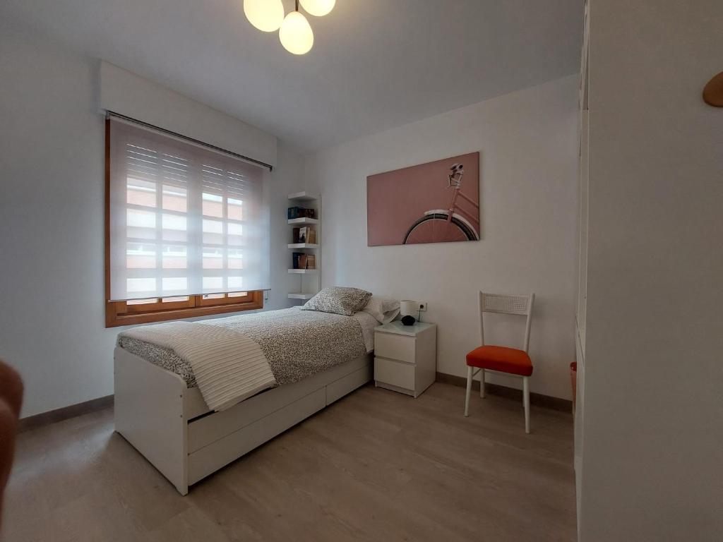 1 dormitorio con 1 cama y 1 silla roja en Reina Doña Urraca, en Palencia