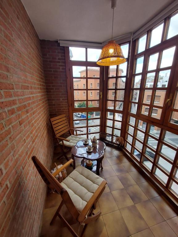 a living room with a couch and a table and windows at Reina Doña Urraca in Palencia