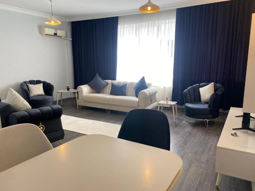 uma sala de espera com sofás e uma mesa e cadeiras em New luxury and quiet apartmant em Istambul