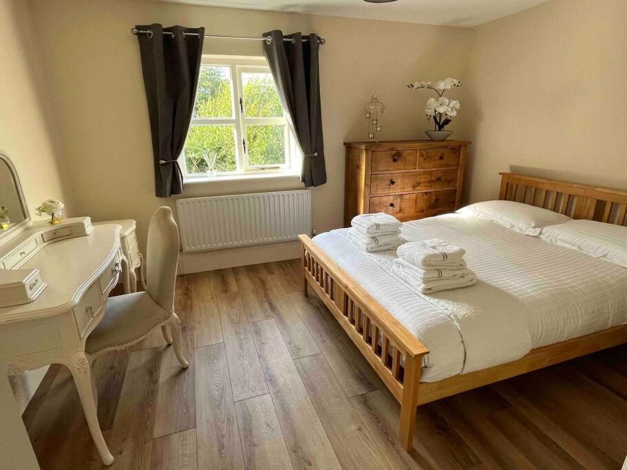 a bedroom with a bed and a desk and a sink at Hillcrest Lodge, Private apartment on Lough Corrib, Oughterard in Galway