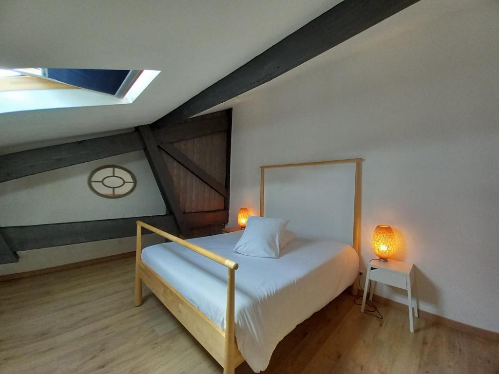 サン・テミリオンにあるLes logis des Vignobles Sainte Emilion en Duplex n 3 avec terrasseのベッドルーム1室(ベッド1台、ライト2つ付)