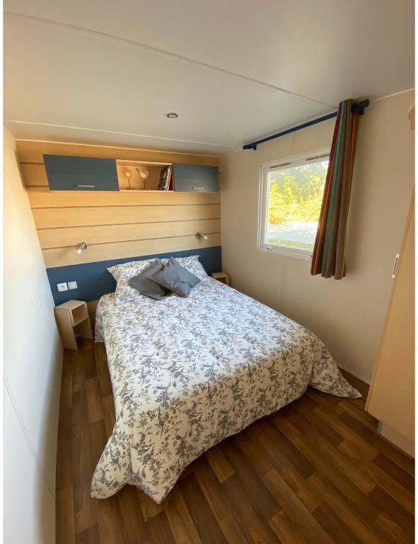 1 dormitorio con cama y ventana en Mobile home proche de Europa Park, en Boofzheim