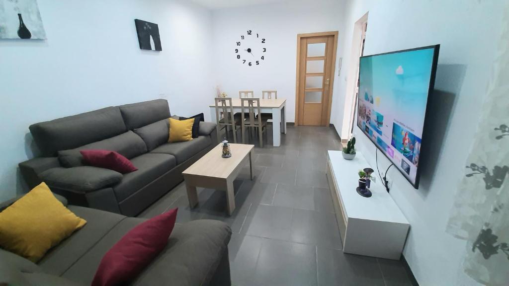 sala de estar con sofá y TV de pantalla plana en Casa planta baja en Elche