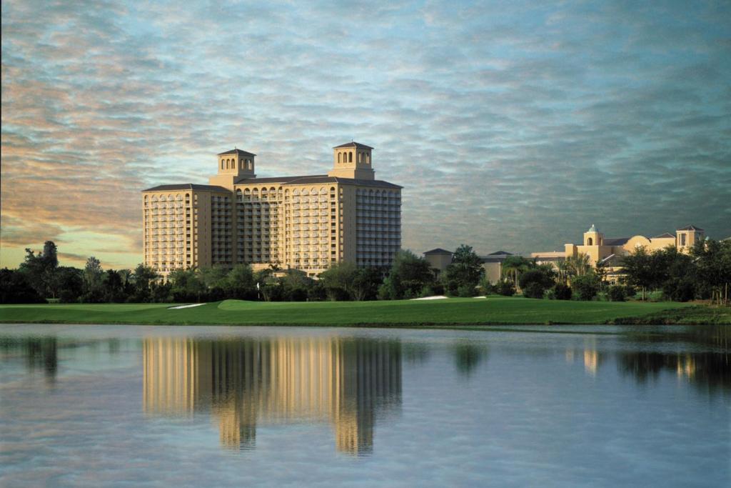 a view of a resort with a reflection in the water at The Ritz-Carlton Orlando, Grande Lakes in Orlando