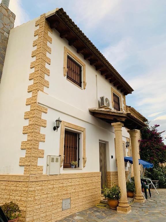 a white house with two windows and a balcony at Venta Judio in Purchena