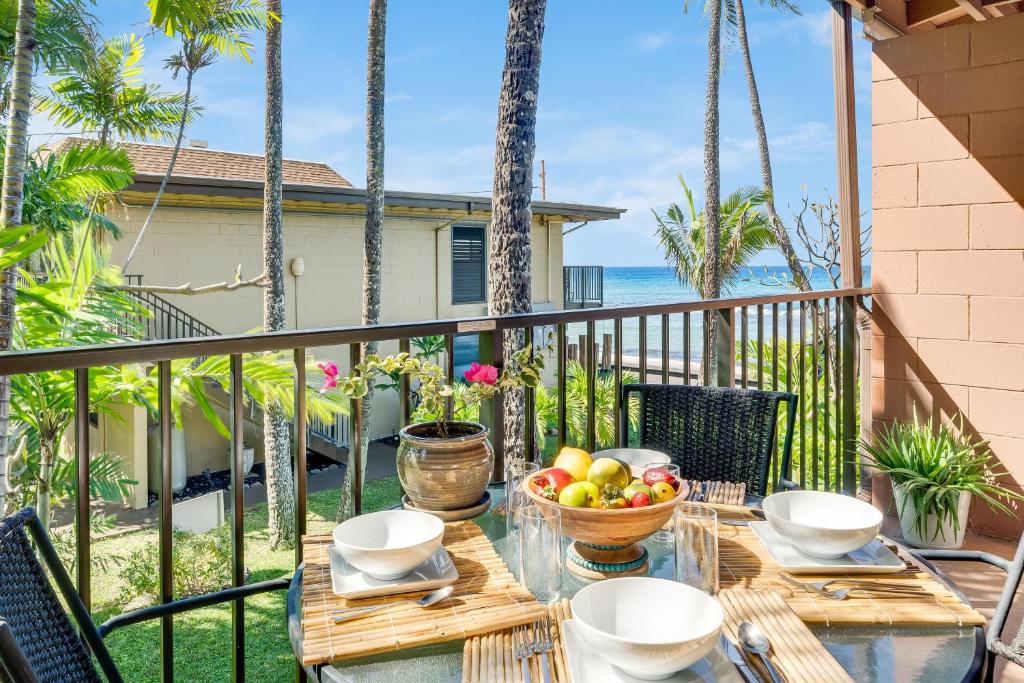 un tavolo con un cesto di frutta sul balcone di Maui Sands Seaside 713 a Kahana