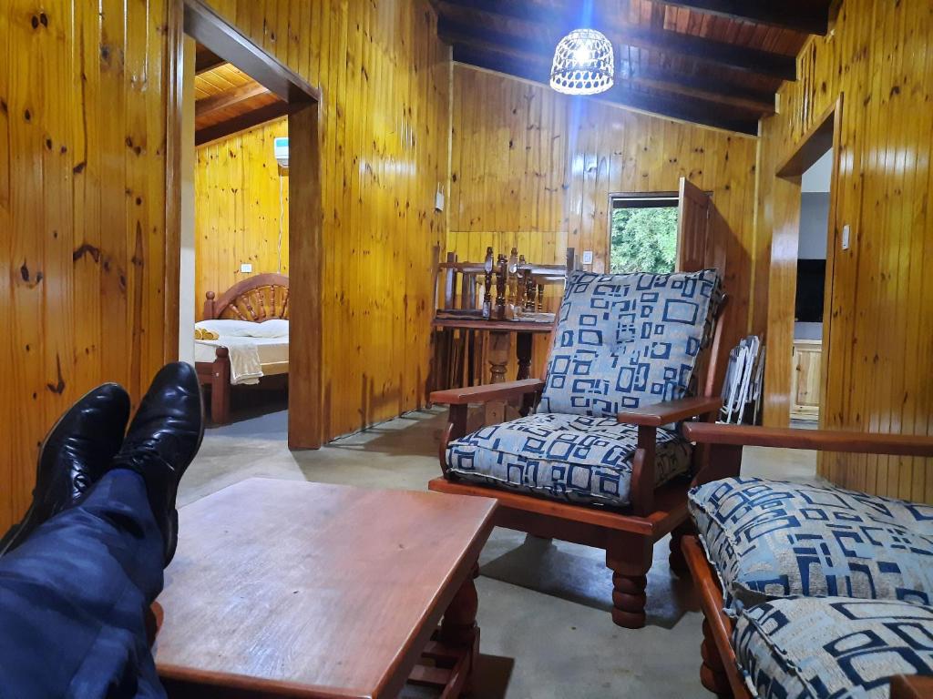 een persoon met zijn voeten op een tafel in een kamer bij Cabaña Buena Madera in San Vicente