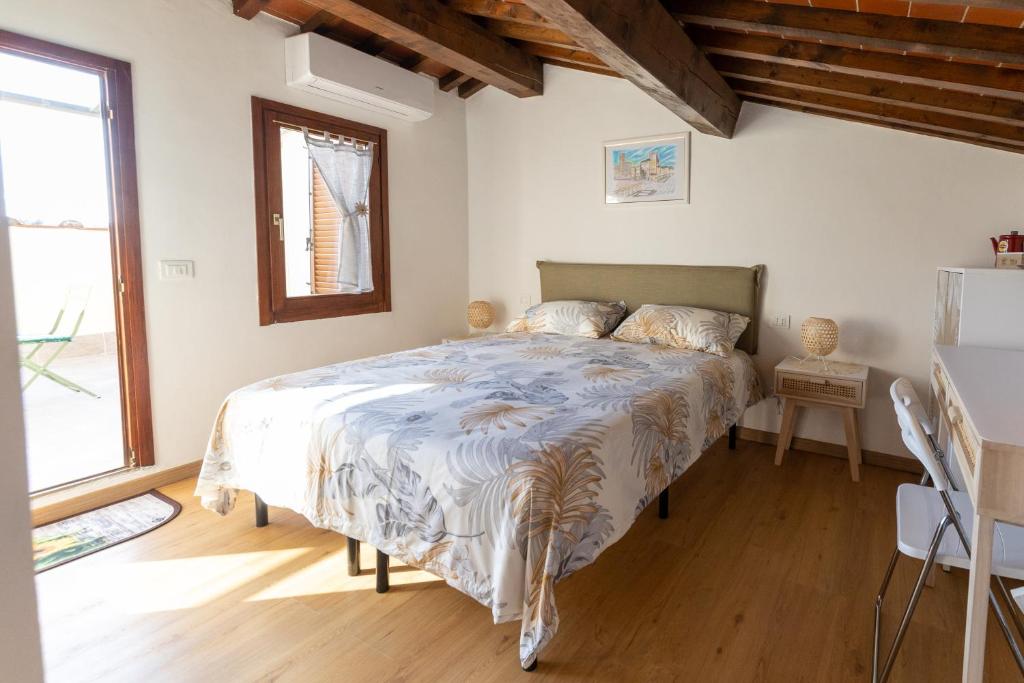 La Terrazza di Emy - affitto turistico في أريتسو: غرفة نوم بسرير ونافذة كبيرة