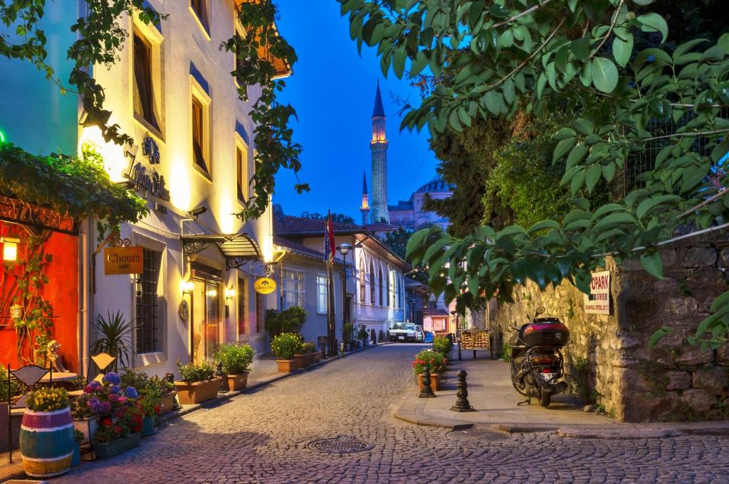 a street in a town with a tower in the background at Zeynep Sultan Hotel in Istanbul
