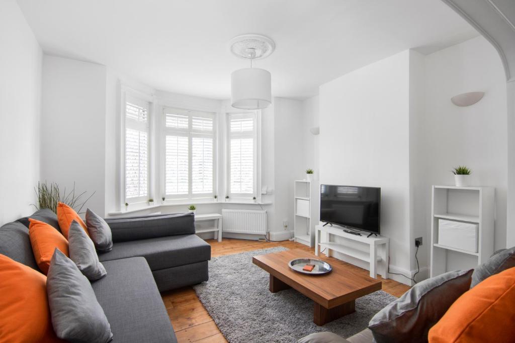 a living room with a couch and a tv at Cloud9 Accommodation in Croydon