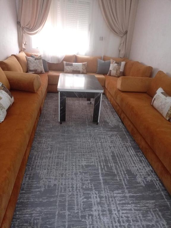 a living room with a large couch and a table at أكادير حي السلام in Agadir