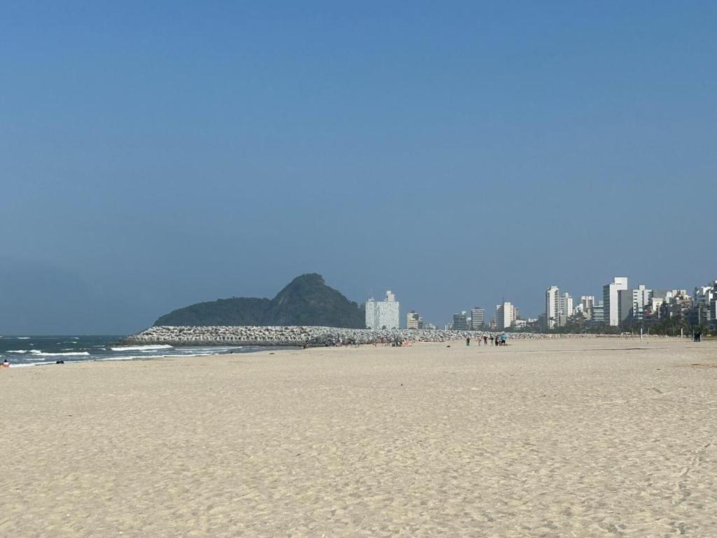 a sandy beach with a city in the background at Apto completo praia Caioba in Matinhos