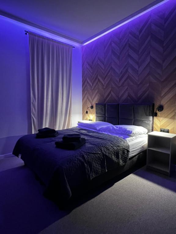 una camera da letto con letto e illuminazione viola di Gamler Apartments by Letrent a Żyrardów