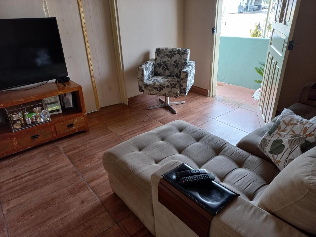 a living room with a couch and a chair at Casinha Verde in Passa Quatro