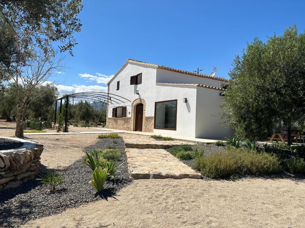 una casa blanca con una puerta en un patio en Mas d'en Jan en Roquetas
